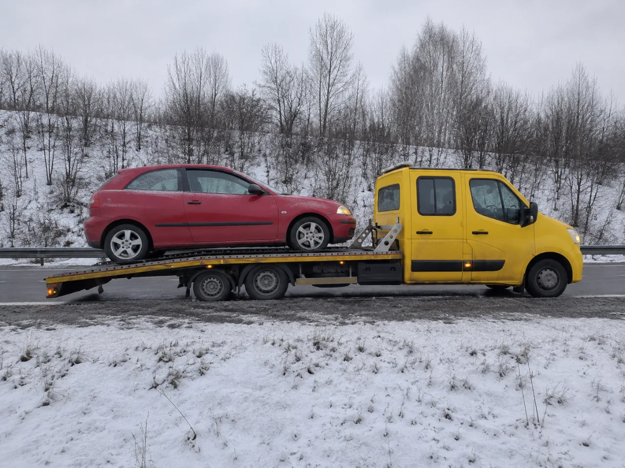 Holowanie czerwonego auta na lawecie zimą – Legionowo